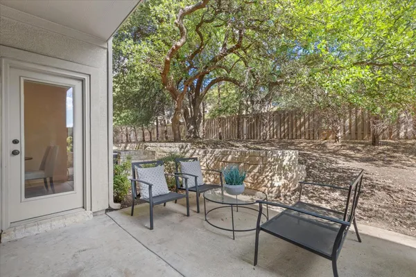 a view of patio with table and chairs and couches with wooden fence