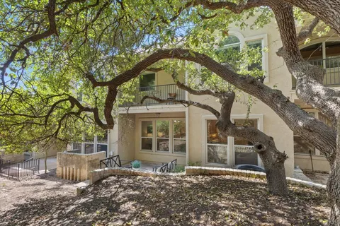 a front view of a house with a tree