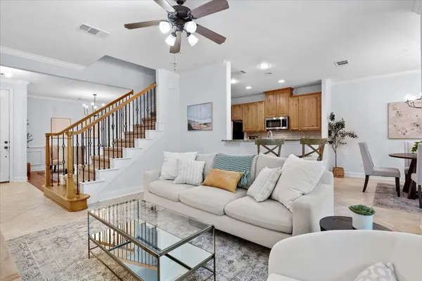 a living room with furniture kitchen view and a wooden floor