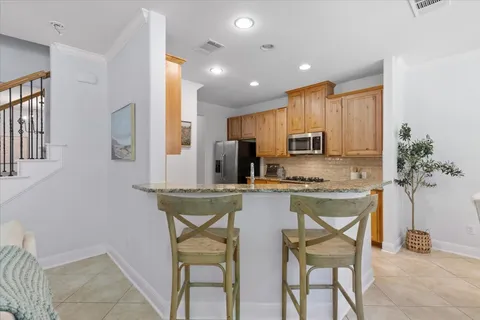 a kitchen with stainless steel appliances granite countertop a stove a sink a refrigerator and a refrigerator