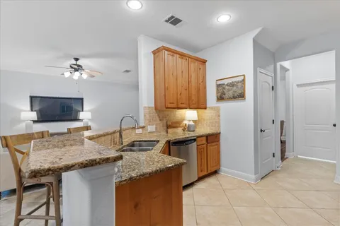 a kitchen with granite countertop cabinets a sink a stove and a refrigerator