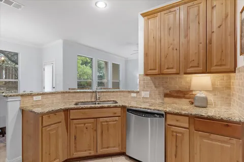 a kitchen with granite countertop cabinets sink and window
