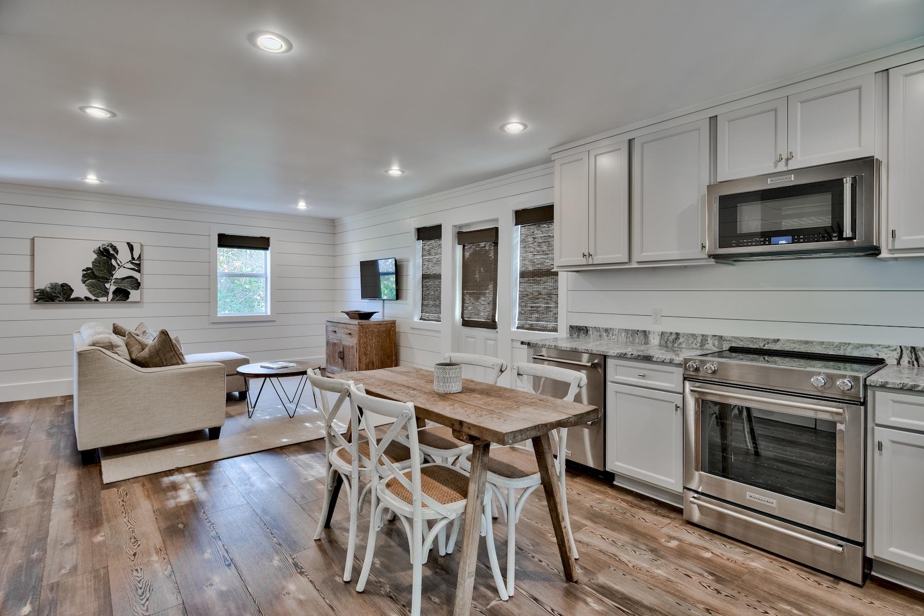 149 East Grove Avenue Santa Rosa Beach, FL 32459 - Photo 34 of 42 a kitchen with stainless steel appliances kitchen island granite countertop a stove a sink a dining table and chairs