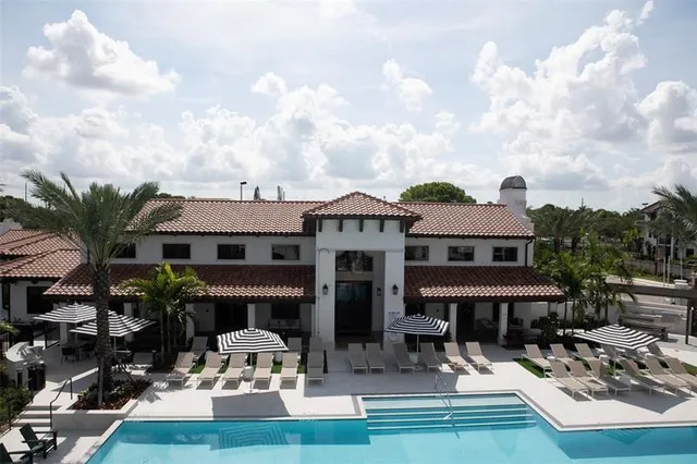 a view of house with swimming pool and furniture
