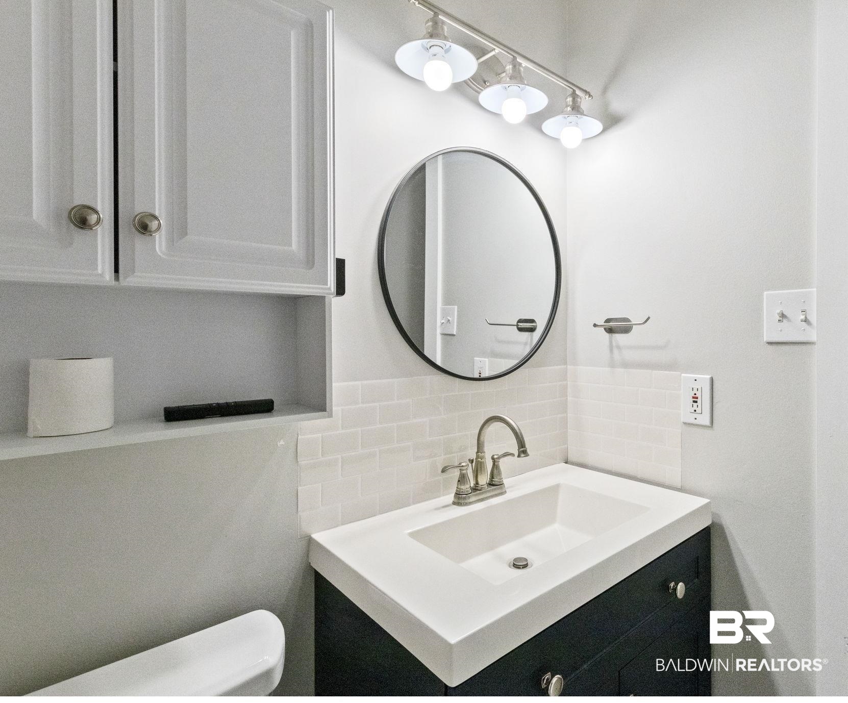 25861 Canal Road, Unit 77 Orange Beach, AL 36561 - Photo 28 of 48 Half bath featuring vanity and backsplash