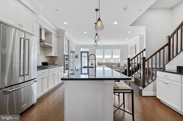a view of entryway and kitchen with wooden floor