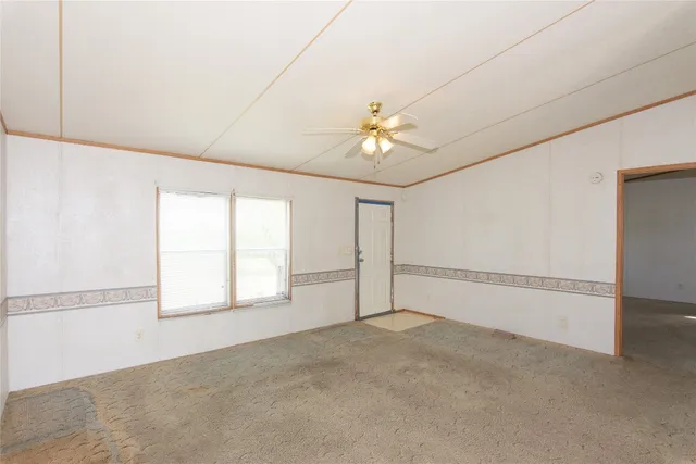 a view of a livingroom with a ceiling fan and window