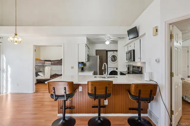 a view of kitchen center island wooden floor and view living room