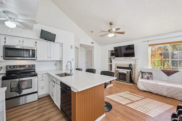a kitchen with a sink a stove cabinets and appliances