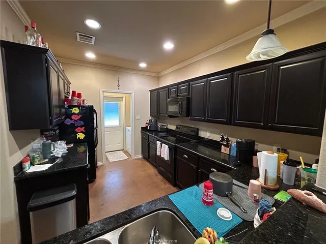 a kitchen with sink refrigerator and cabinets