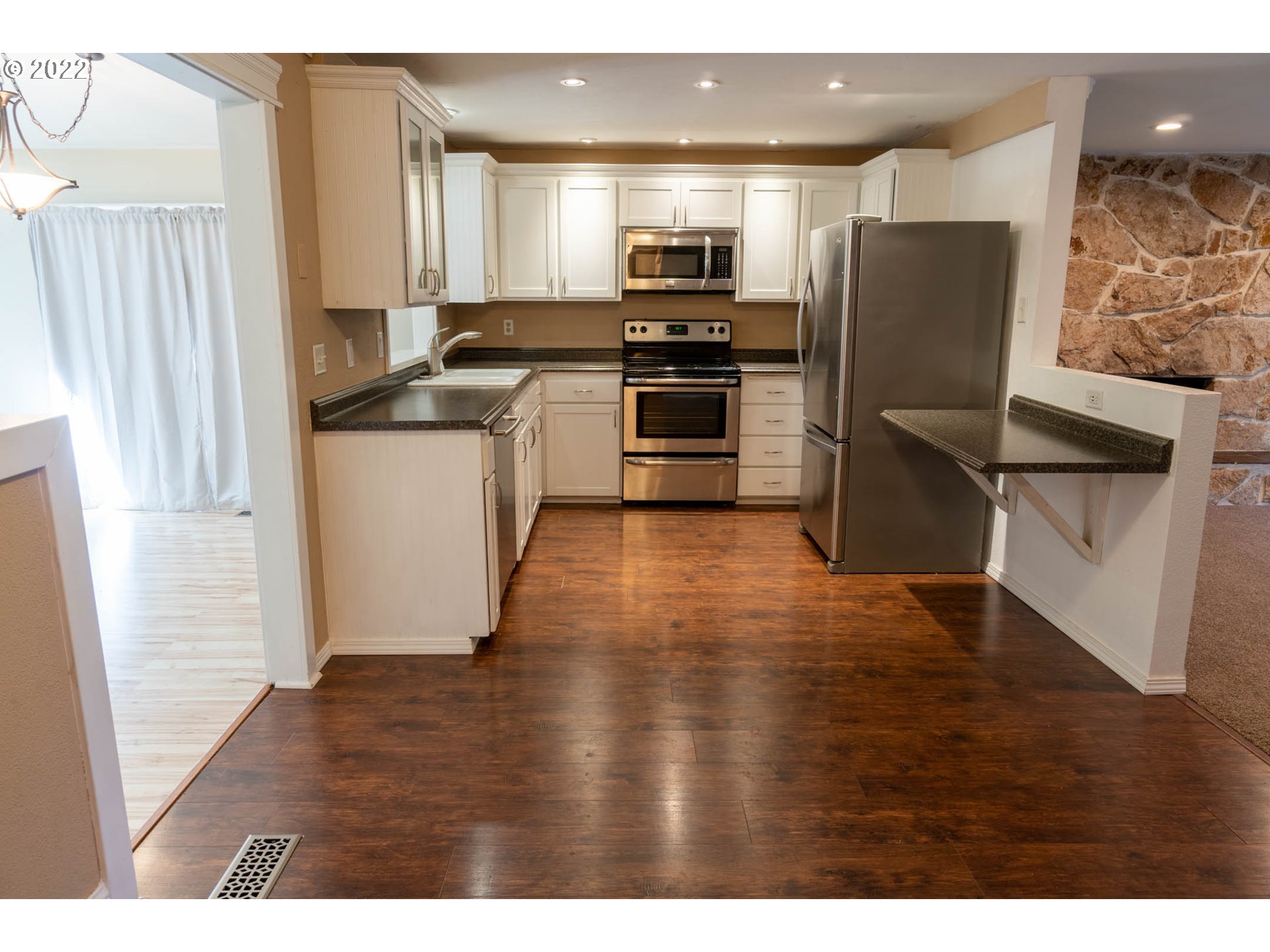 384 69th Place Springfield, OR 97478 - Photo 6 of 20 a kitchen with granite countertop a refrigerator stove and sink