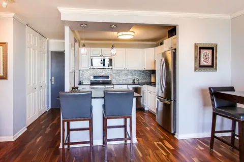 a kitchen with white cabinets and appliances
