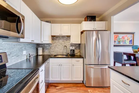 a spacious bedroom with a bed and a night stand