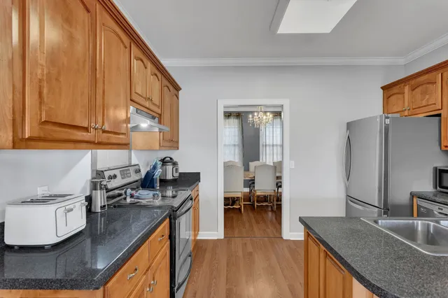 a kitchen with stainless steel appliances granite countertop a sink stove and refrigerator