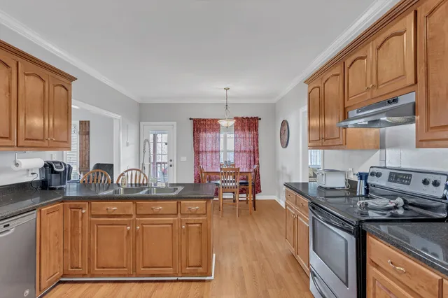 a kitchen with stainless steel appliances granite countertop a sink stove and cabinets
