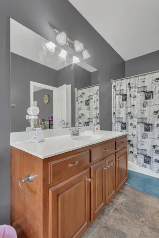 a bathroom with a granite countertop sink a large mirror and a shower
