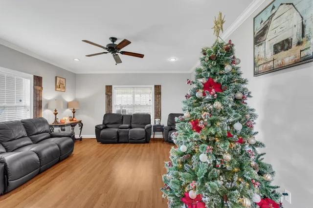 a living room with furniture flowers and a potted plant