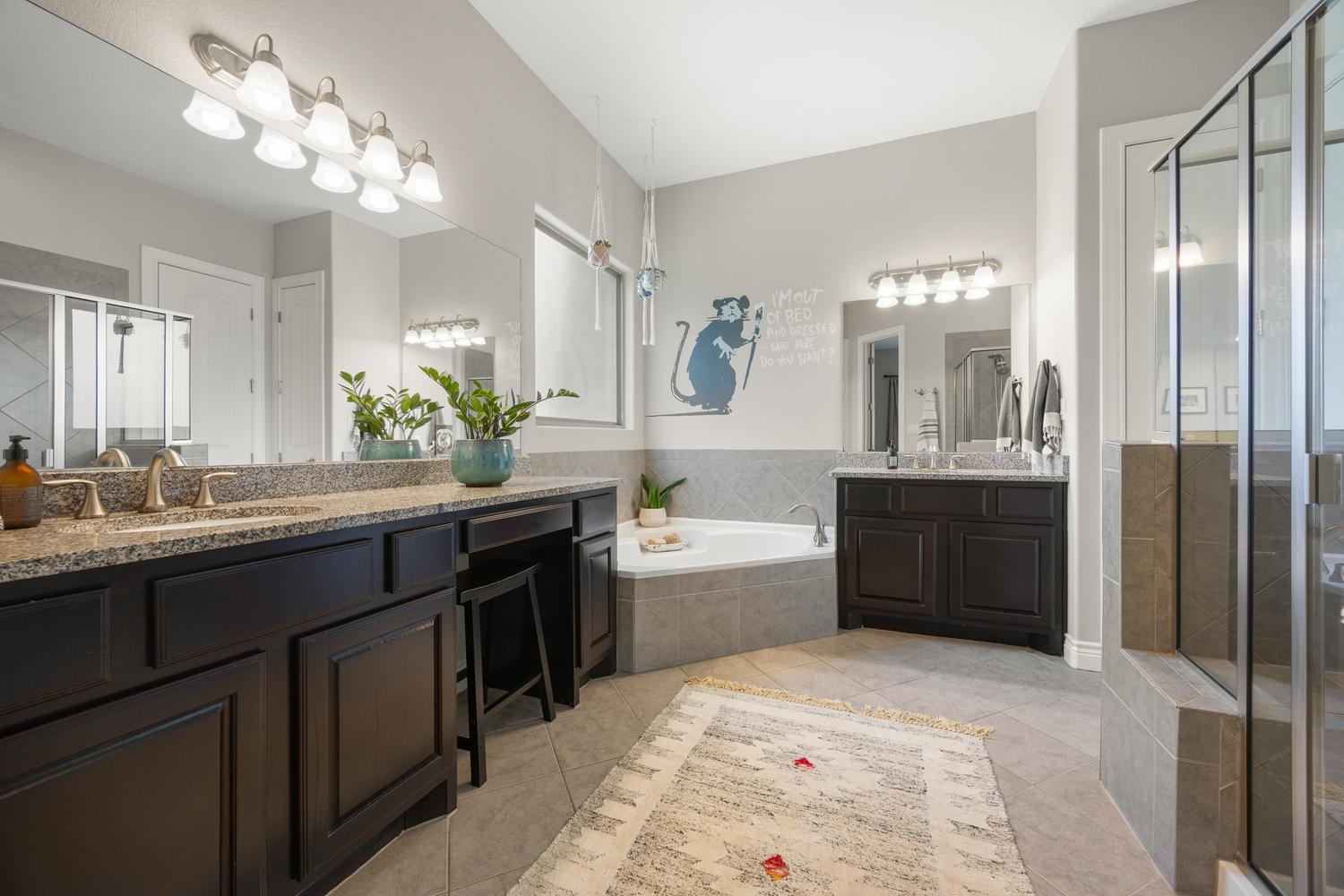 1135 Blue Ridge Drive Dripping Springs, TX 78620 - Photo 18 of 36 Dual vanities with granite counters and a corner soaking tub define this well-appointed primary bathroom.