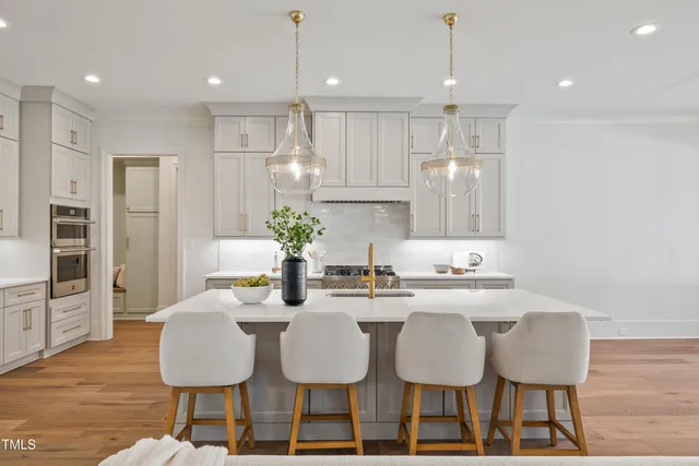 a kitchen with granite countertop a kitchen island and chairs in it