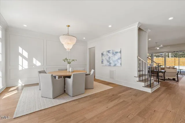 a living room with couches a table and chairs with wooden floor