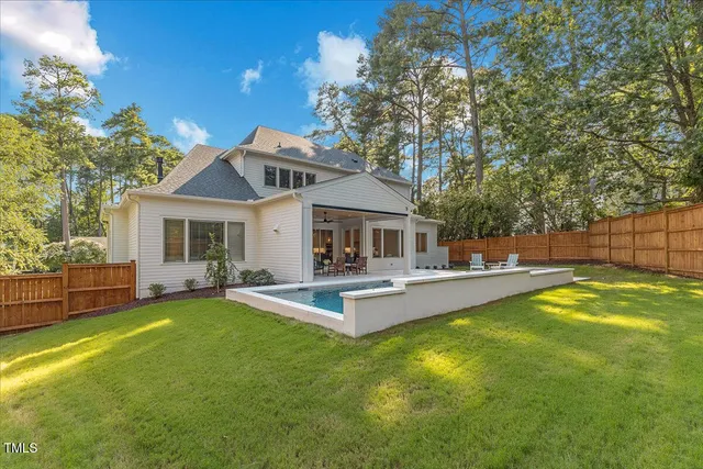 a view of a backyard with couches under an umbrella
