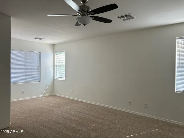 an empty room with a window and a fan