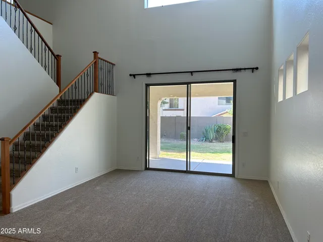 a view of an empty room with wooden floor and windows