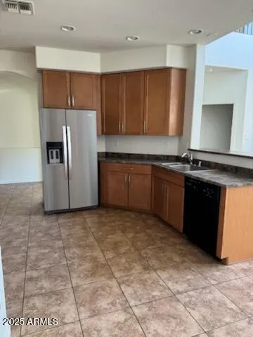 a kitchen with stainless steel appliances granite countertop a stove a refrigerator a sink and dishwasher
