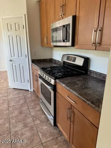 a kitchen with granite countertop a stove a sink and a microwave