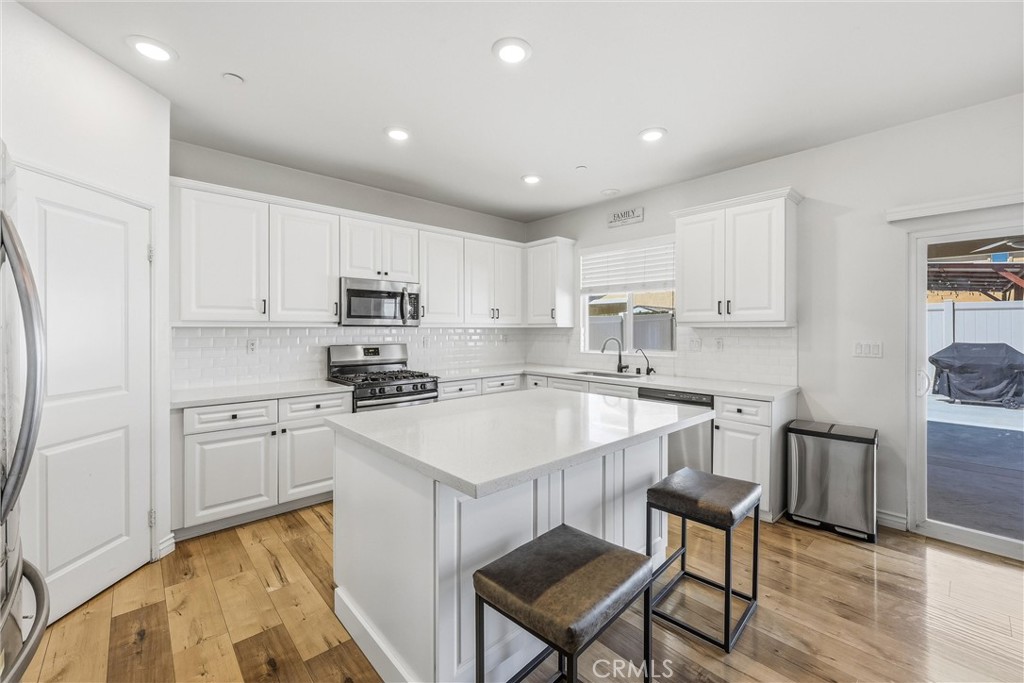 4783 Vanderham Way Eastvale, CA 91752 - Photo 11 of 29 a kitchen with a sink stove cabinets and wooden floor