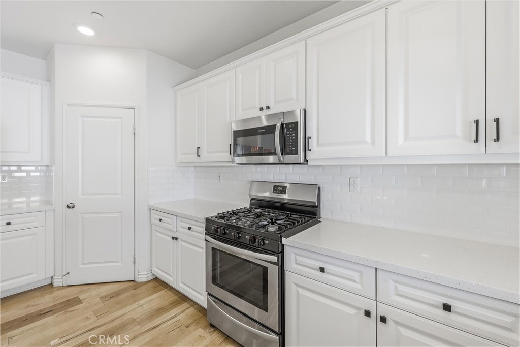 4783 Vanderham Way Eastvale, CA 91752 - Photo 13 of 29 a kitchen with white cabinets and stainless steel appliances