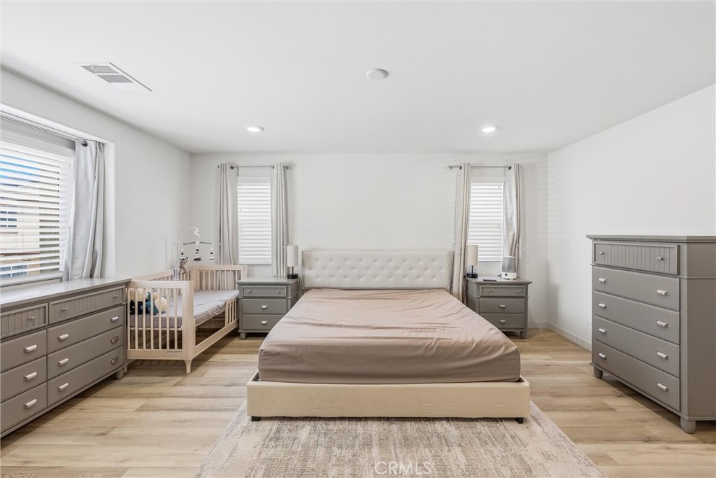 4783 Vanderham Way Eastvale, CA 91752 - Photo 21 of 29 a spacious bedroom with a large bed and a window