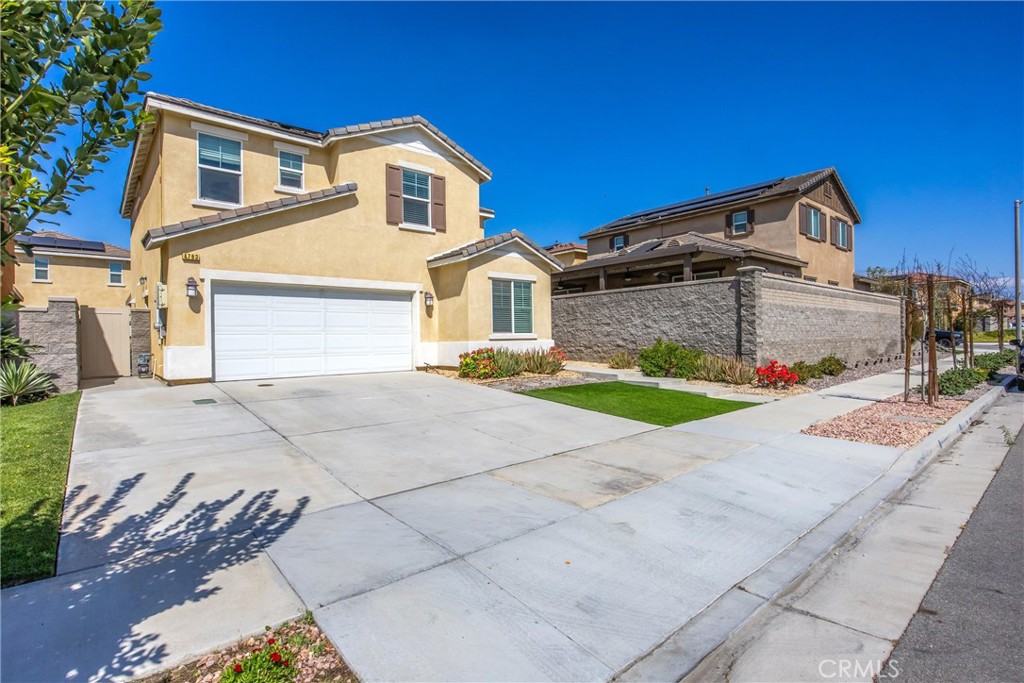 4783 Vanderham Way Eastvale, CA 91752 - Photo 3 of 29 a front view of a house with a yard and garage