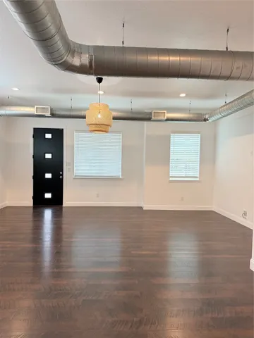 a view of a room with gym equipment and wooden floor