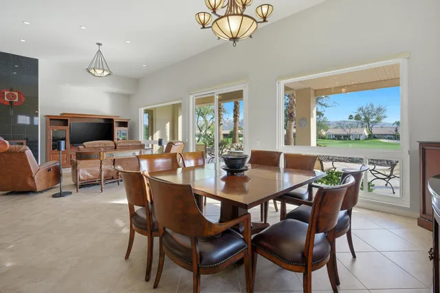 a view of a dining room with furniture a chandelier and wooden floor