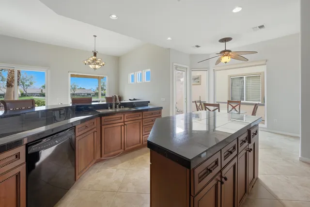 a kitchen with a stove a sink dishwasher a kitchen island with wooden cabinets and floor