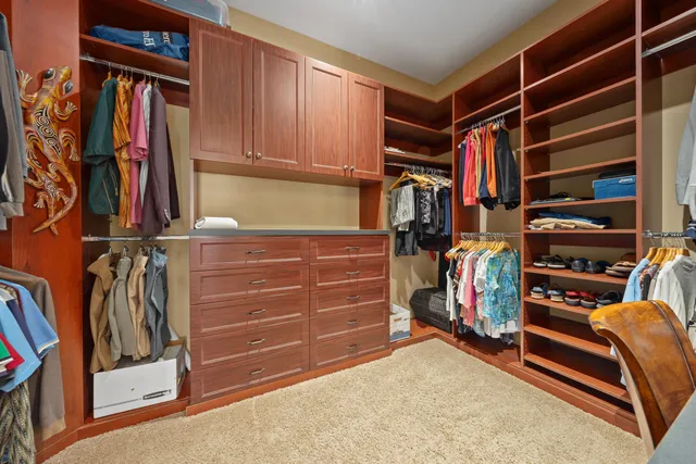 a view of walk in closet with clothes and shoes