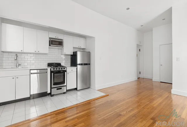 a kitchen with white cabinets and stainless steel appliances