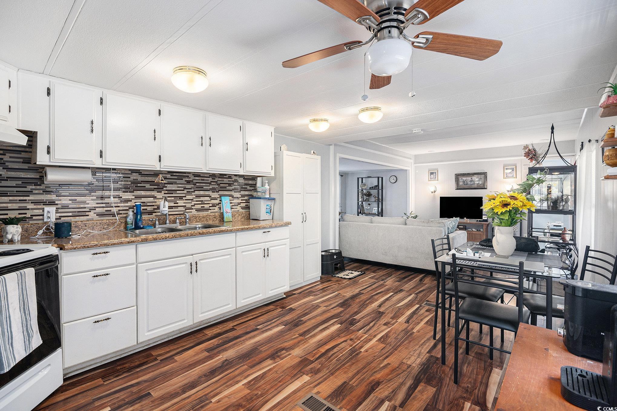 63 Saxon Court Murrells Inlet, SC 29576 - Photo 4 of 22 Kitchen featuring white cabinetry, freestanding refrigerator, electric stove, dark wood-style floors, and tasteful backsplash