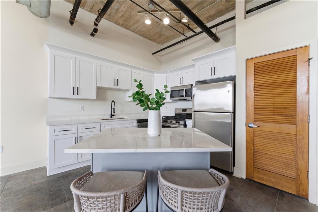 505 Whitehall Street Southwest, Unit 307 Atlanta, GA 30303 - Photo 1 of 35 a kitchen with a refrigerator and white cabinets