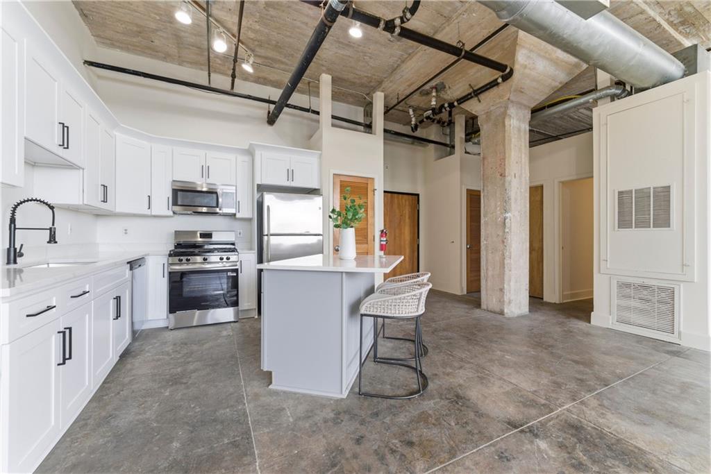 505 Whitehall Street Southwest, Unit 307 Atlanta, GA 30303 - Photo 2 of 35 a kitchen with cabinets and chairs