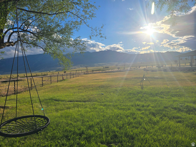 34200 Coulam Road Swan Lake, ID 83281 - Photo 21 of 24 Expansive green space featuring a large lawn area, distant mountain scenery, and a tree with a hanging swing