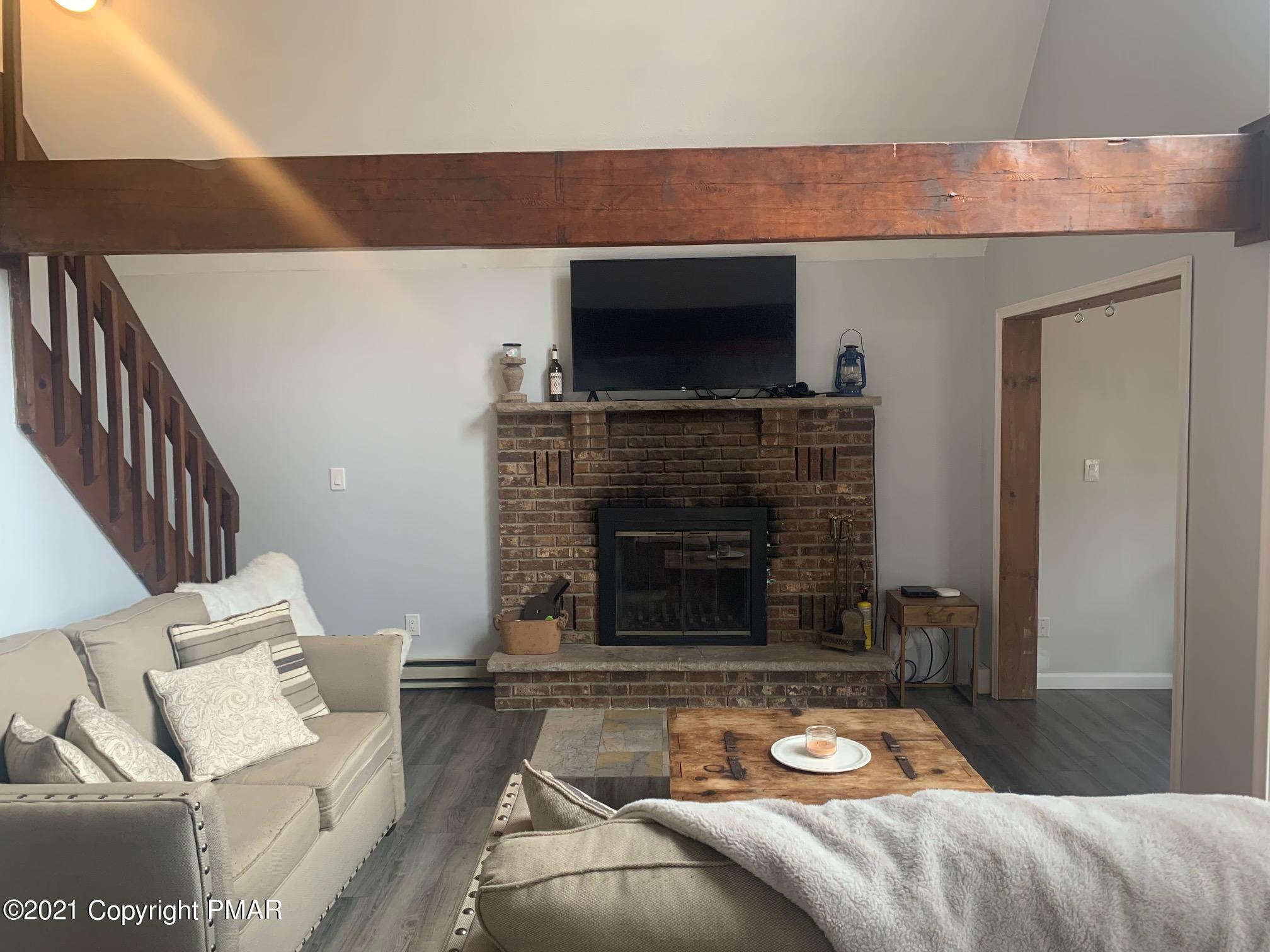 1090 Hampstead Road Bushkill, PA 18324 - Photo 6 of 24 a living room with furniture a flat screen tv and a fireplace