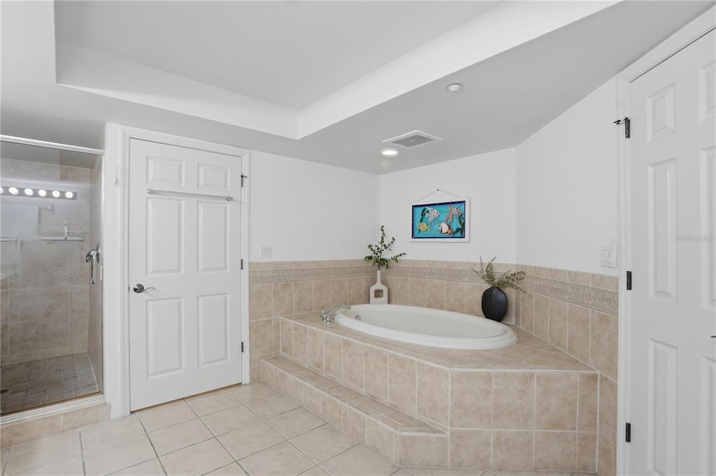 16326 Gulf Boulevard, Unit 307 Redington Beach, FL 33708 - Photo 20 of 43 a bathroom with a tub sink and mirror