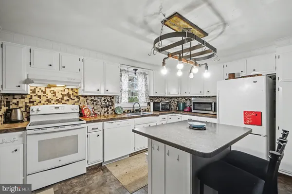 a kitchen with a sink a stove and cabinets