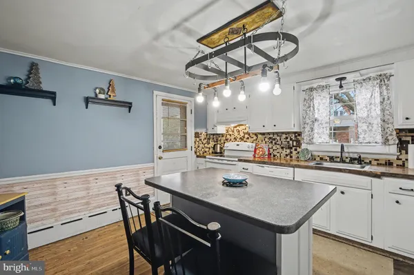 a kitchen with a table chairs cabinets and wooden floor
