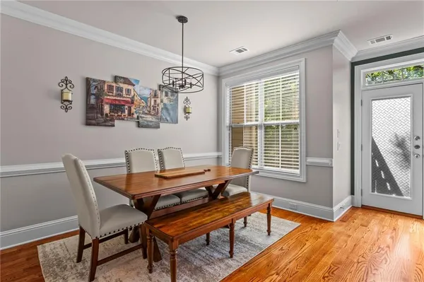 a dining room with furniture a chandelier and wooden floor