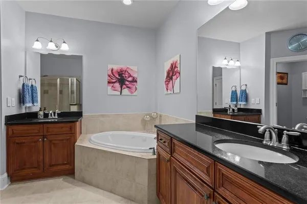 a bathroom with a granite countertop bathtub sink and mirror