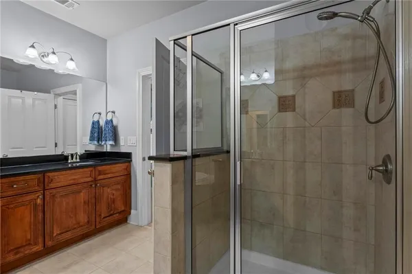 a bathroom with a granite countertop sink a mirror a vanity and shower