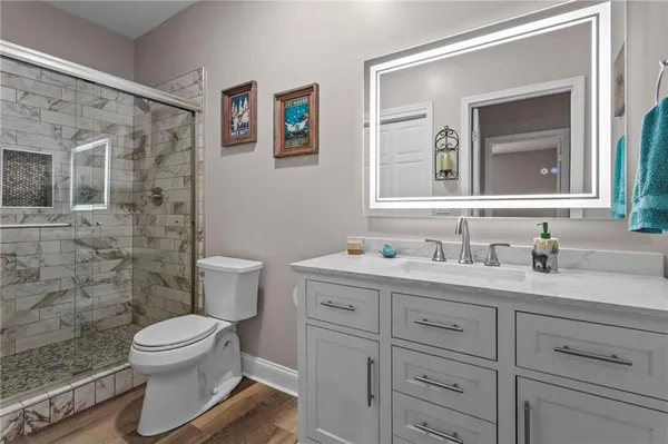 a bathroom with a granite countertop toilet sink and a mirror